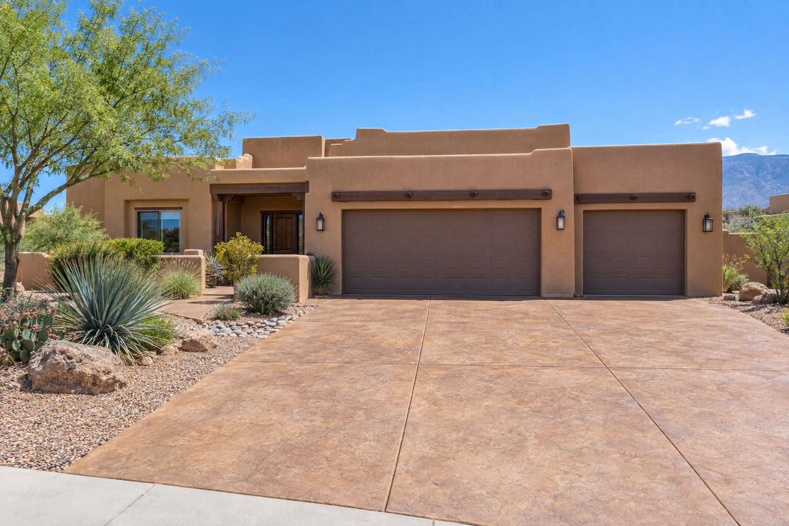 Adobe-style home with a wide stamped concrete driveway